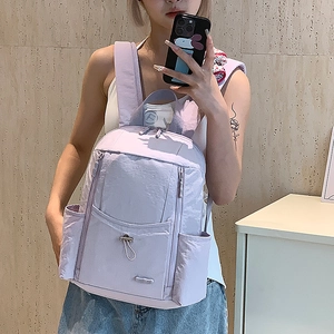 Mirror selfie showing the large capacity light purple nylon backpack for women