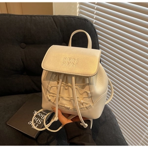 Detail of mini pearl backpack featuring braided drawstrings and elegant pearl accents