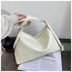 Detail of off-white hobo bag showing pebbled leather texture and adjustable strap buckle
