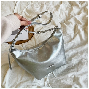 Detailed macro of silver metallic hobo bag with leather texture and chain strap
