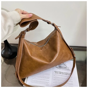 Detail of caramel brown slouchy hobo bag with adjustable strap and zip closure