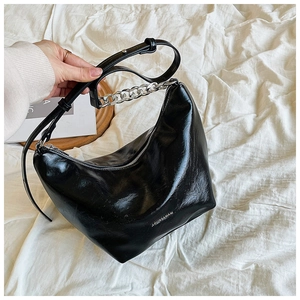 Close-up of black hobo bag with silver chain strap and brand lettering logo