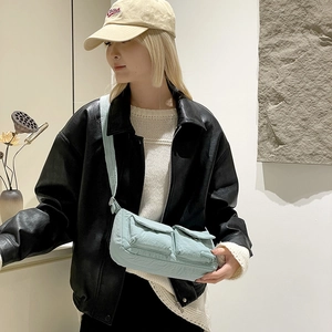 Detail showing two front utility flap pockets and wrinkled nylon texture on the mint bag