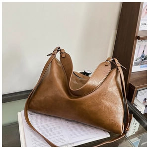 Detail view of brown oil-wax leather texture on a retro Hobo shoulder bag with zip closure