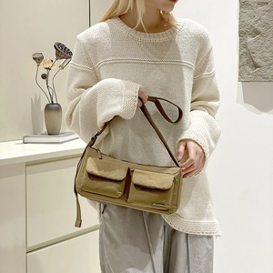 Detailed view of khaki nylon messenger bag featuring double front flap pockets and wide strap