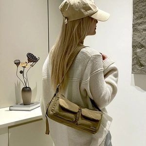 Detailed side view of khaki nylon crossbody bag showing multiple pockets on a model