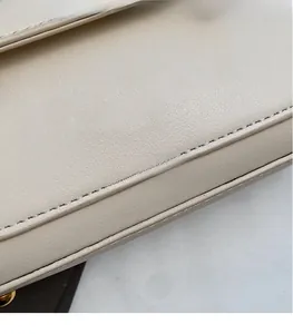 Close-up of beige leather crossbody bag with golden embossed logo and fine stitching
