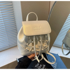 Close-up of pearl-white mini backpack with ARMI lettering and pearl string details