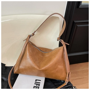 Close-up of vintage brown leather dumpling tote bag with silver zipper and adjustable strap