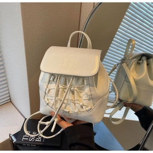 Detail of white leather mini backpack with pearl accents and embossed logo on the flap