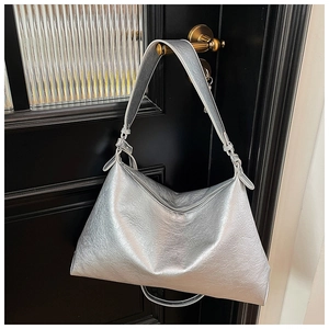 Detail of metallic silver tote bag with crinkled texture and wide shoulder strap