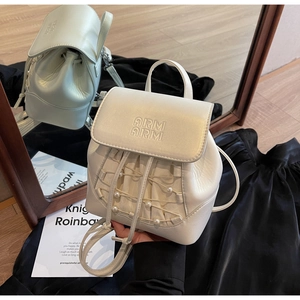 Detailed view of cream mini backpack with pearl accents and adjustable leather straps