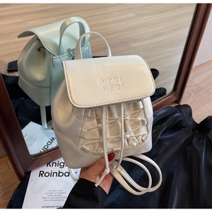 Close-up of mini white pearl backpack featuring drawstring closure and embossed texture