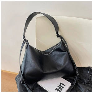 Detail of minimalist black dumpling bag with premium lychee grain texture and silver zipper