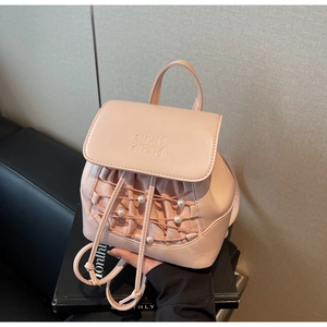 Detail of pink mini backpack featuring pearl decor, textured leather, and drawstring detail