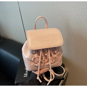 Detail of pink mini backpack featuring cross-woven straps and white pearl embellishments