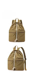Detail view of khaki nylon drawstring backpack with dual front zip pockets and side structure