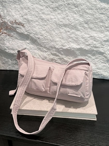 Pink nylon messenger bag with multi-pocket design and adjustable wide shoulder strap