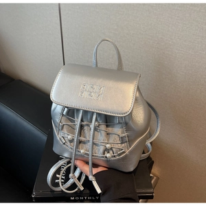Detail of silver metallic mini backpack with pearl accents and embossed flap texture