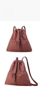 Macro detail of dark red drawstring backpack showing durable waterproof nylon texture