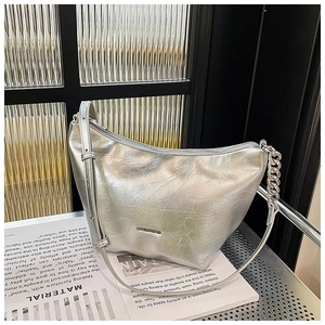 Close-up of silver metallic hobo bag with pleated texture and stylish chain detail