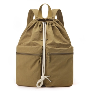 Macro detail of khaki nylon drawstring backpack showing smooth metal zippers and white ropes