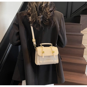 Fashionable beige leather small crossbody bag styled with a professional black blazer