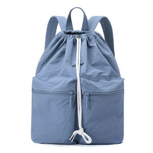 Detail of drawstring closure and dual zip pockets on grey-blue nylon backpack