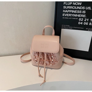 Detailed shot of pink mini backpack featuring pearl decor and delicate mesh drawstring