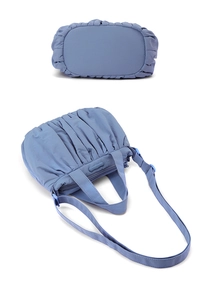 Detailansicht der blauen Nylon-Cloud-Tasche mit Falten, Tragegriff und verstellbarem Riemen