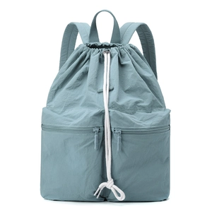 Detail view of Morandi blue nylon backpack showing drawstring closure and front zip pockets