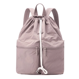 Close-up of light purple drawstring backpack with zip pockets and nylon texture