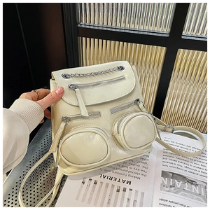 Detail van gebroken witte PU-leren rugzak met zilveren ketting en multi-pockets