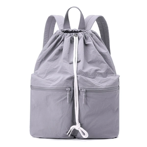 Front view of light gray nylon drawstring backpack with dual zippered outer pockets