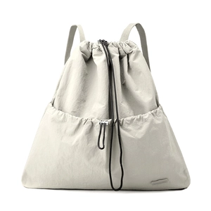 Detail of grey water-resistant nylon drawstring backpack with front pocket and brand label