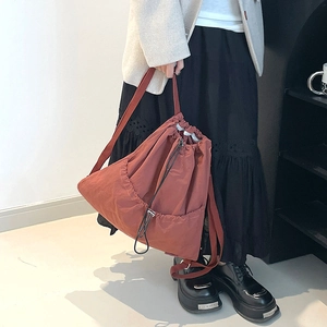 Close-up of lightweight terracotta drawstring backpack with minimalist nylon texture