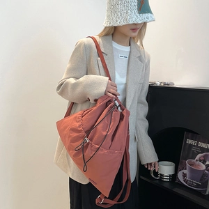 Close-up of terracotta nylon drawstring backpack with side zipper and adjustable straps