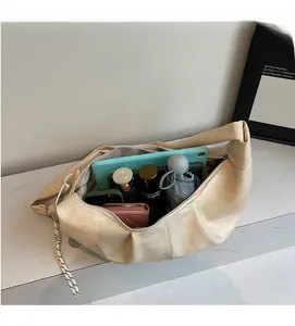 Spacious interior of a beige crescent bag showing tablet, wallet, and umbrella storage