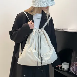 Detail of off-white nylon drawstring backpack showing lightweight texture and drape