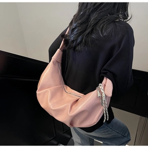 Pink crescent shoulder bag with artistic pleats and woven knot charm detail