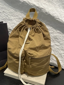 Minimalist nylon drawstring backpack in khaki with dual front zipper pockets and top handle