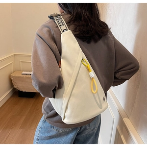 Detail view of stylish cream chest bag with SJCHA strap and yellow drawstring detail