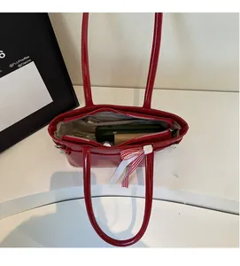 Vue intérieure d'un sac à bandoulière en cuir verni rouge montrant les compartiments