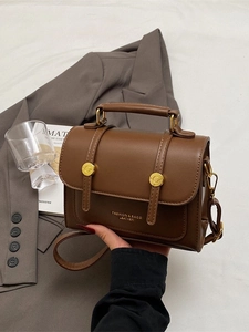 Deep brown leather crossbody messenger bag with gold hardware in fashion blogger style