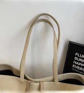 Detailed close-up of smooth long shoulder straps on a beige canvas tote bag for women