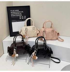 Detailed view of assorted colors Boston bags with embossed letters and stylish charms