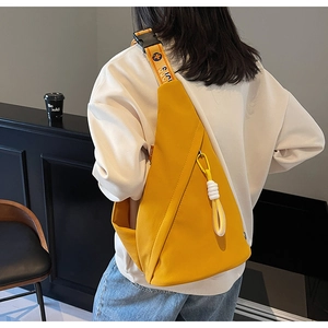 Macro shot of stylish yellow triangular chest bag with white rope detail and Sugi strap