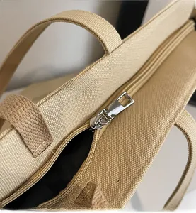 Close-up of smooth metal zipper and textured canvas fabric on a large tote bag