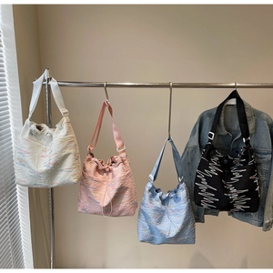 Detail of four colorful canvas bucket bags with textured fabric and wave embroidery