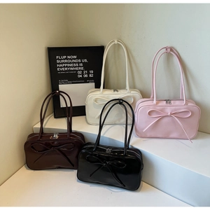 Multiple bow knot shoulder bags in brown, cream, pink and black on a display stand